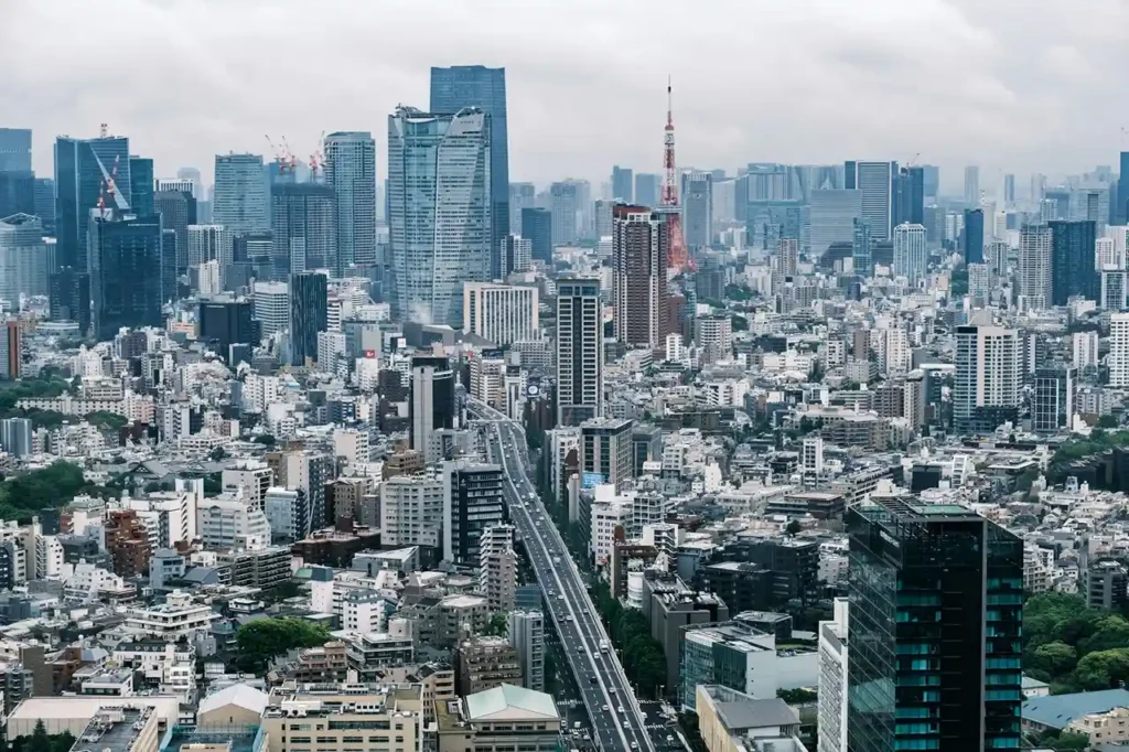 A panoramic view of Tokyo city skyline from a high-rise building, showcasing skyscrapers and urban landscape.