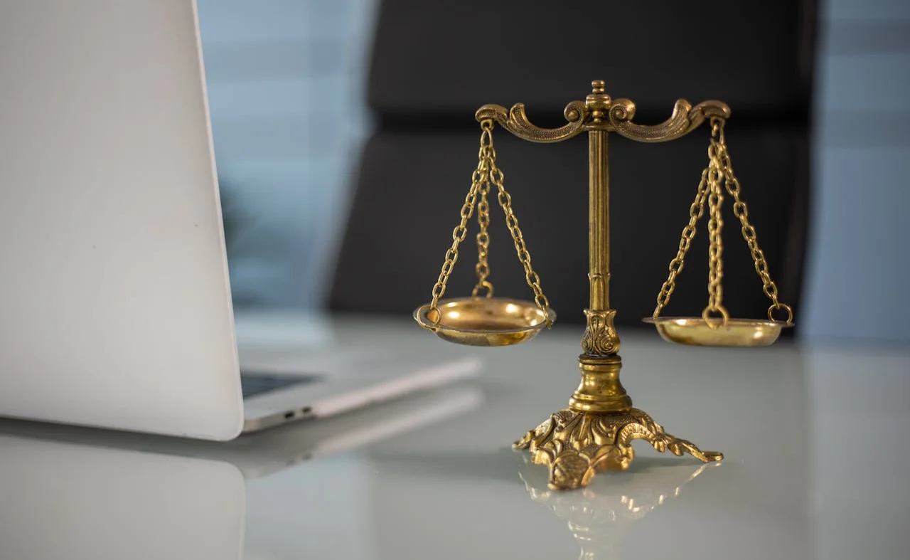 Lawyer sitting at a table with a laptop open, focused on work in a professional office setting.